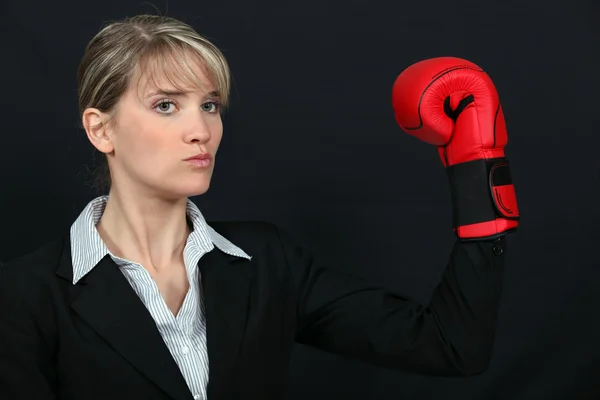 Businesswoman wearing a boxing glove — Stock Photo, Image