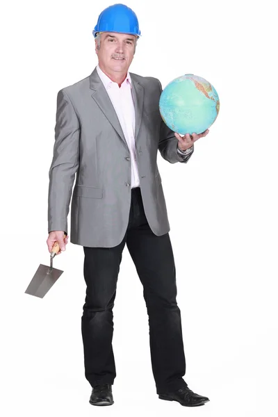Muž v obleku drží Globus a stěrky — Stock fotografie