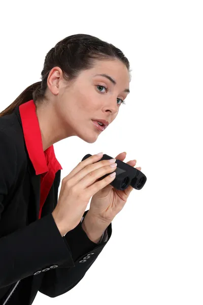 Uma mulher de negócios espionando com binóculos . — Fotografia de Stock