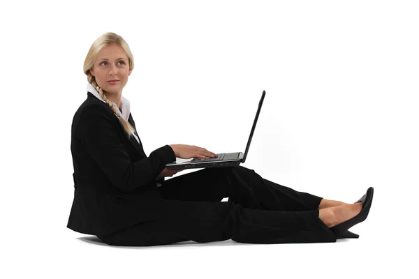 Kobieta siedzi na podłodze z jej laptop. — Zdjęcie stockowe