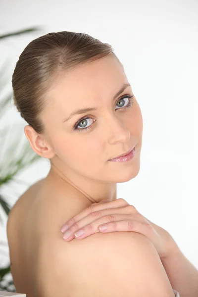 Jovem mulher em uma toalha olhando por cima do ombro — Fotografia de Stock