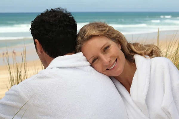 Par i badrockar på stranden — Stockfoto