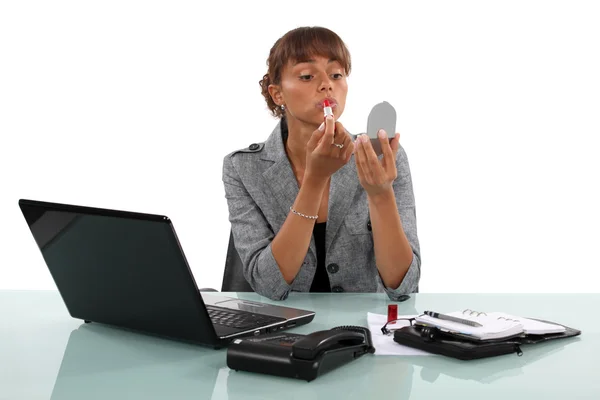 Donna che si mette il rossetto sul posto di lavoro — Foto Stock