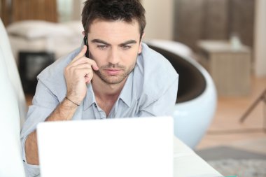 Man on the phone at the computer clipart