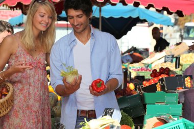 Couple choosing vegetables at the market clipart