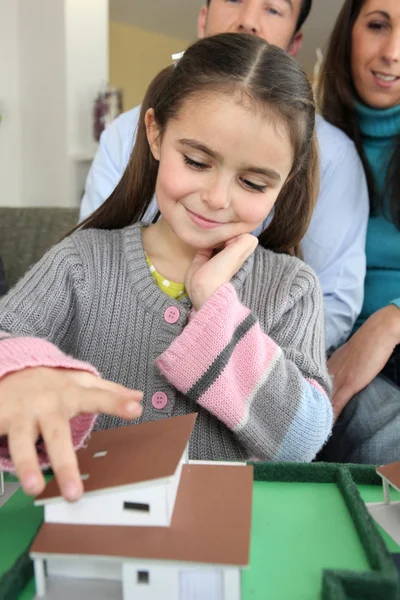 Маленька дівчинка грає з модельним будинком — стокове фото