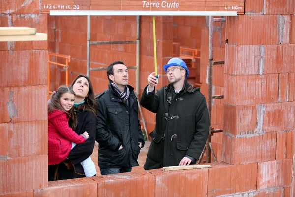 Family and contractor on construction site — Stock Photo, Image