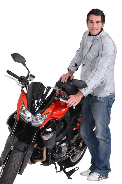 Молодий чоловік стоїть поруч з мотоциклом — стокове фото