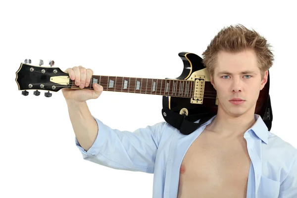 Серйозний молодий чоловік з гітарою над плечем — стокове фото