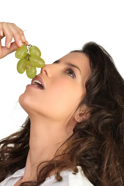 Jeune femme mangeant des raisins — Photo