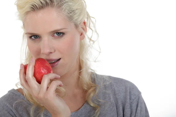 Mujer rubia comiendo manzana roja — Foto de Stock