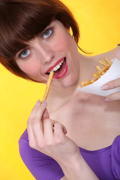 フライド ポテトを食べるブルネット — ストック写真