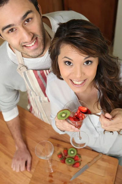 Casal na cozinha com morangos e quivi — Fotografia de Stock