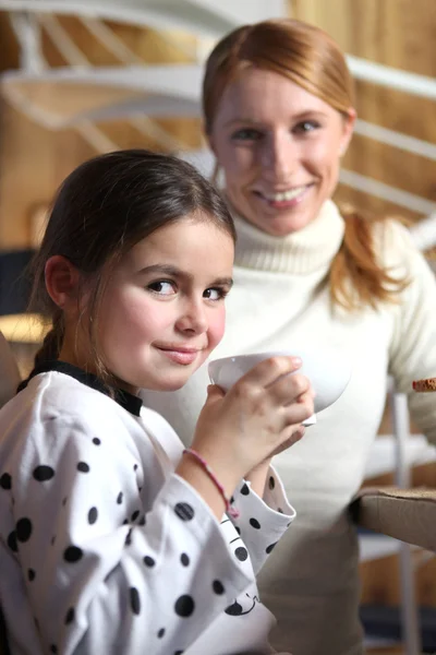 Menina bebendo de caneca grande no café da manhã — Fotografia de Stock