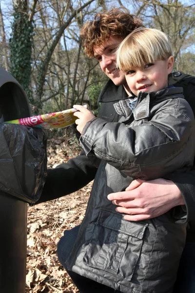 Отец и сын перерабатывают листовки — стоковое фото