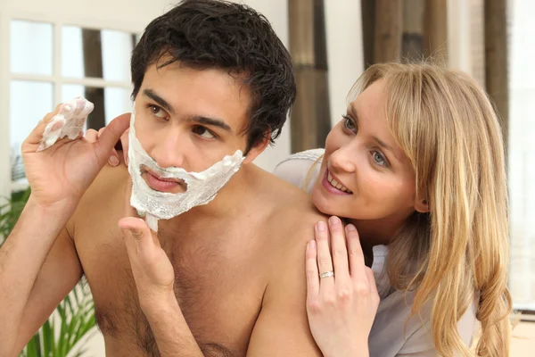 Женщина смотрит на мужское бритье — стоковое фото