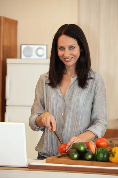 Morena picando verduras en la cocina —  Fotos de Stock