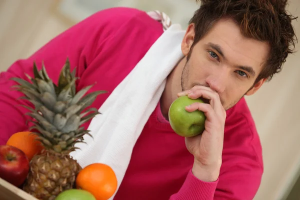 Fundersam ung man äta frukt — Stockfoto