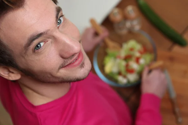 Jonge man opgooien van een salade — Stockfoto