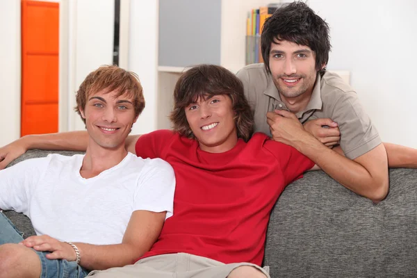 Trzech młodych mężczyzn na kanapie — Zdjęcie stockowe