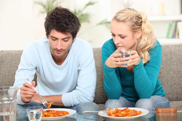 Couple having dinner on the sofa — Stock Photo, Image