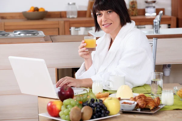 Vrouw ontbijten in de keuken — Stockfoto