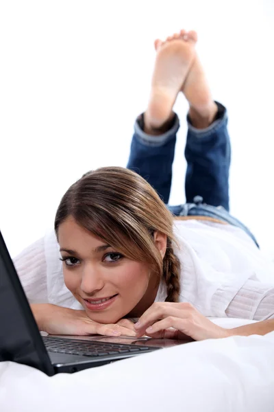 Vrouw kijken naar haar laptop in bed — Stockfoto