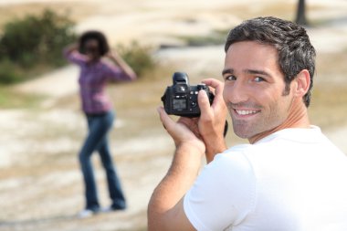 Man taking a picture of his girlfriend clipart