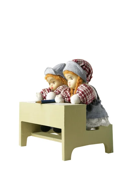 Zwei Puppen auf einer Spielzeugschulbank — Stockfoto