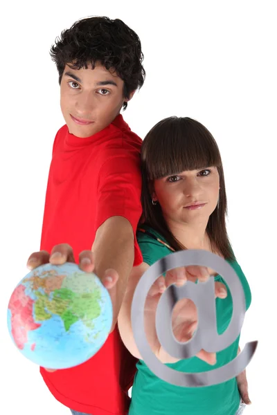 Подростки с глобусом и при знаке — стоковое фото