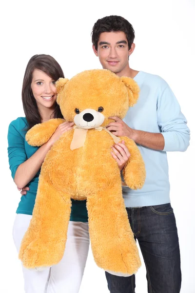 Jovem casal segurando grande brinquedo urso — Fotografia de Stock