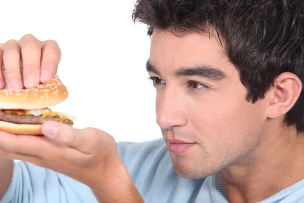 Portret van een jonge man met hamburger — Stockfoto