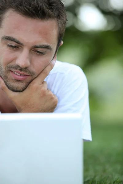 Homem usando seu laptop em um parque — Fotografia de Stock