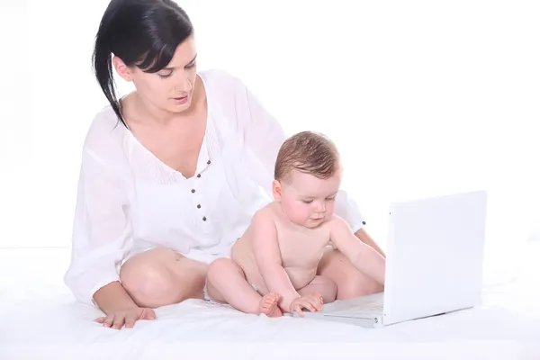 Mother with her baby in front of a laptop — Stock Photo, Image