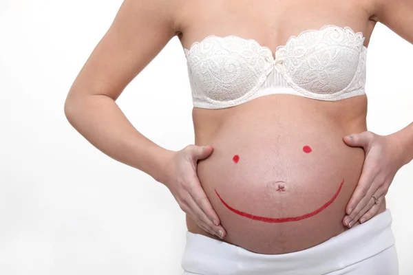 Kobieta w ciąży z uśmiechem na jej guz — Zdjęcie stockowe