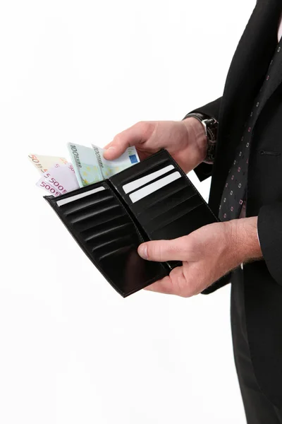 Empresario sacando un fajo de dinero de su billetera — Foto de Stock