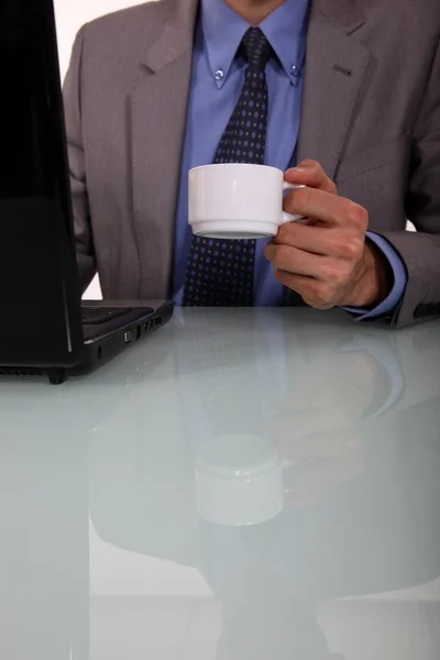 Επιχειρηματίας με ένα καφέ και ένα φορητό υπολογιστή — Φωτογραφία Αρχείου