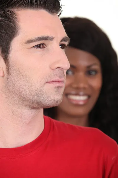 Uma mulher negra sorrindo e um homem branco sério — Fotografia de Stock