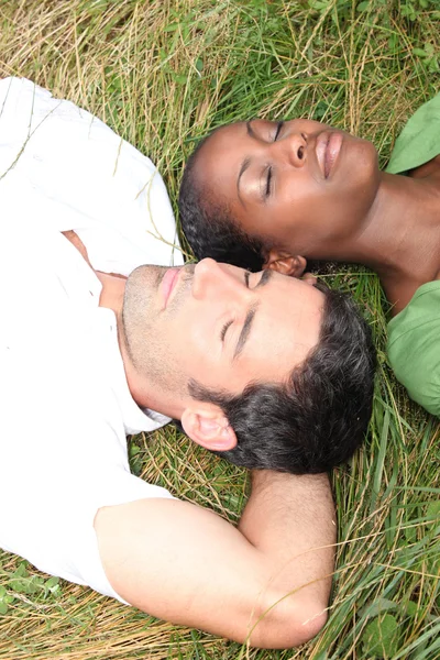 Par liggande i gräs — Stockfoto