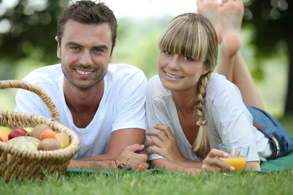 Par med romantisk picknick i ett fält — Stockfoto