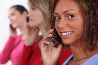 A row of women talking on their cellphones clipart