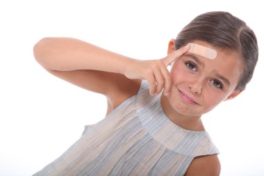 Injured child with a plaster on her forehead clipart