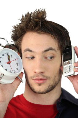 Man holding alarm clock and mobile telephone clipart