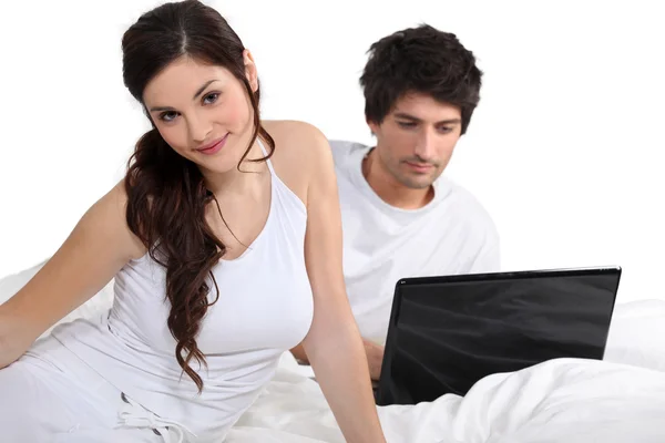 Casal na cama com um laptop — Fotografia de Stock
