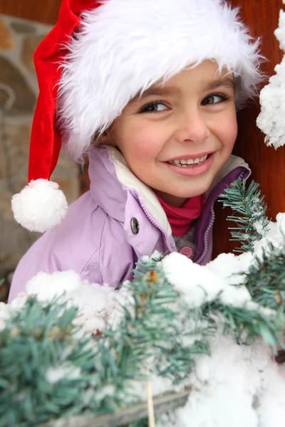 Malá holčička v santa hat stál strom — Stock fotografie