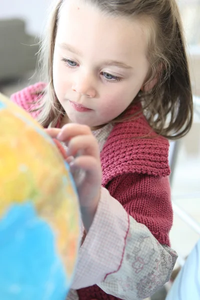 Маленькая девочка смотрит на глобус — стоковое фото