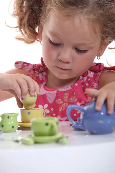 Młoda dziewczyna gra z zestaw herbaty — Zdjęcie stockowe