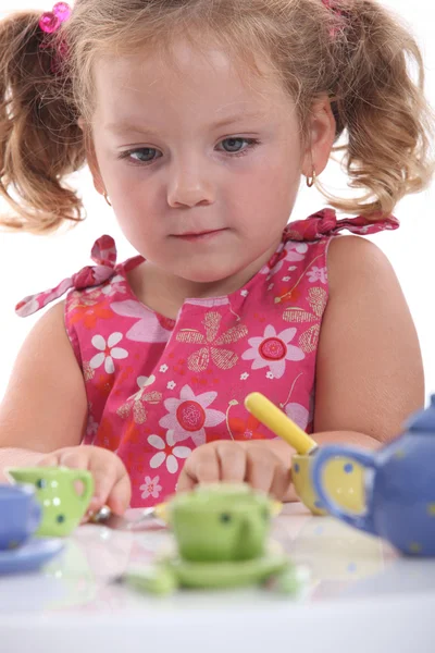 Young girl playing with her tea set — Stock Photo, Image