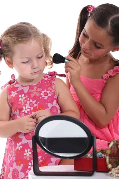 Две маленькие девочки играют с макияжем — стоковое фото