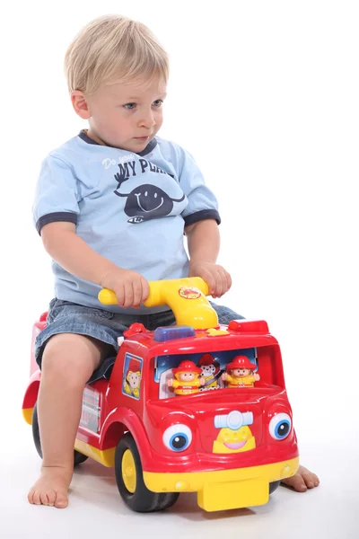 Küçük çocuk oyuncak arabayla oynuyor. — Stok fotoğraf